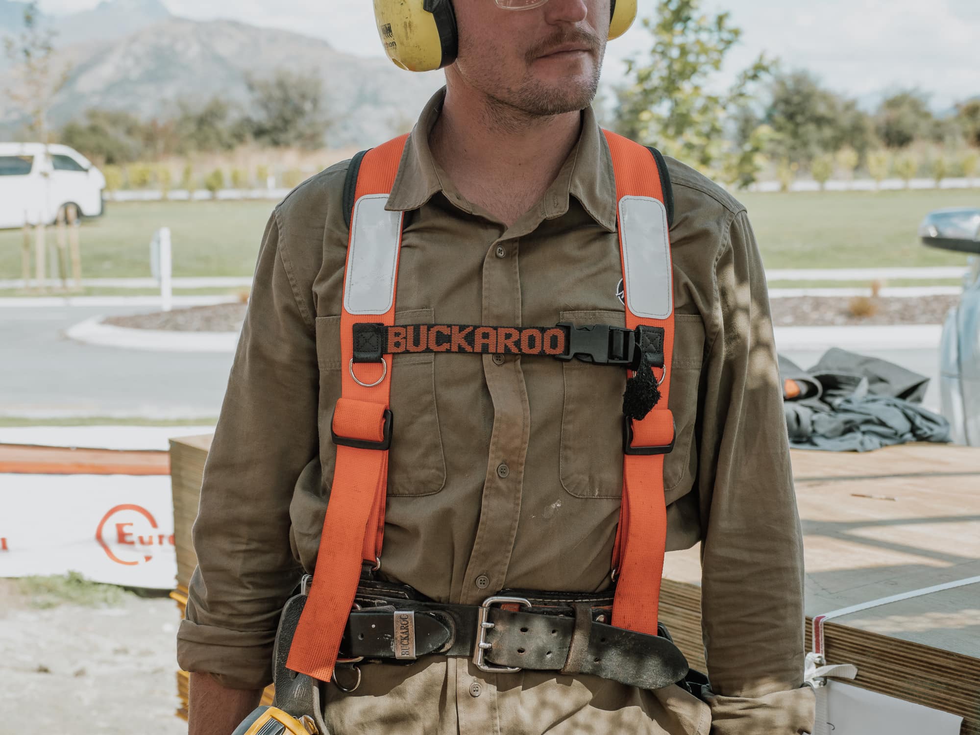 A Matthew Lucas Building carpenter in harness on site, mountains behind